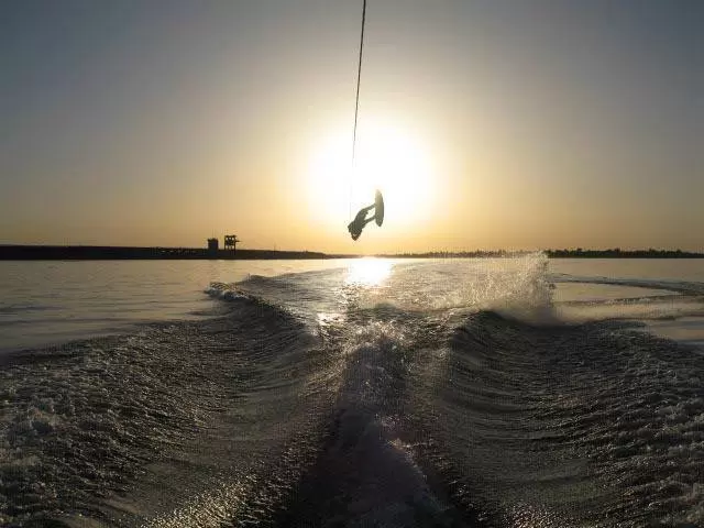 A person wakeboarding on Lake Norfork at sunset